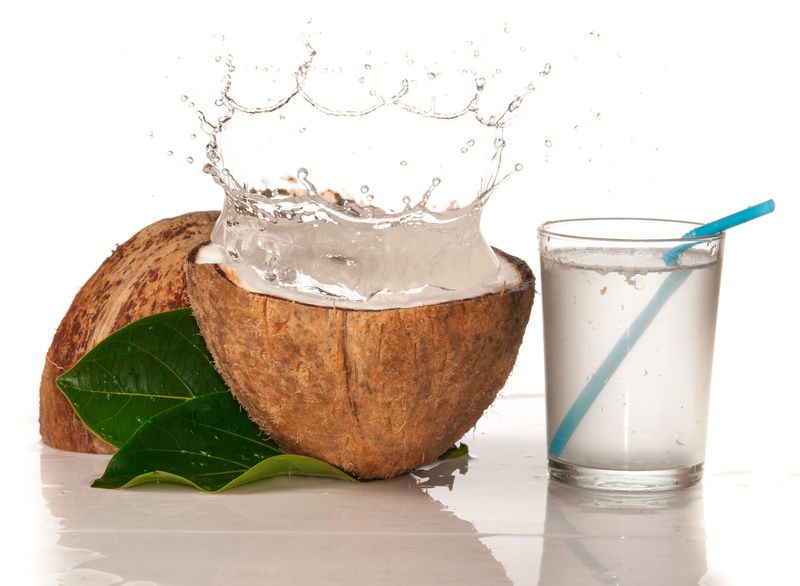 Coconut With Water Splash Over White